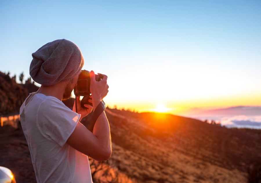 Photographe devant un coucher de soleil